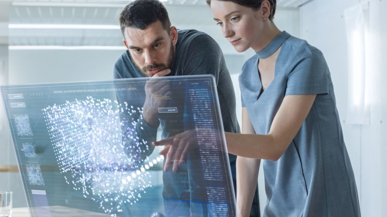 Un hombre y una mujer ante una pantalla transparente