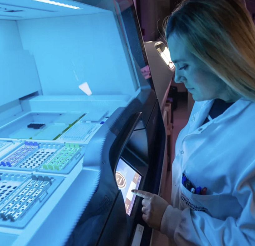 Mujer manejando una máquina de análisis