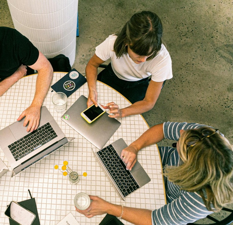 Dos mujeres y un hombre participan en una reunión 