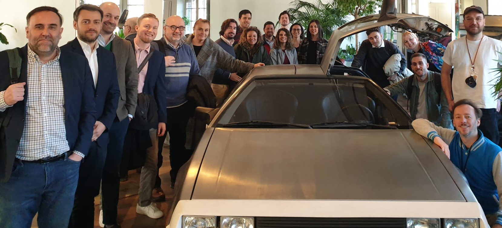 Foto de grupo en la Embajada de Estonio en Berlín junto a un coche DeLorean.