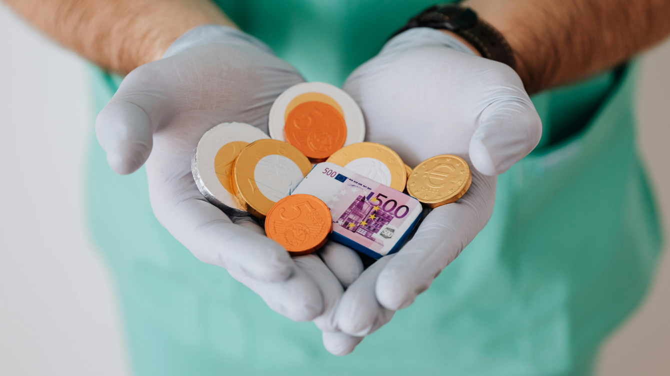 Un sanitario coge entre sus manos monedas de chocolate
