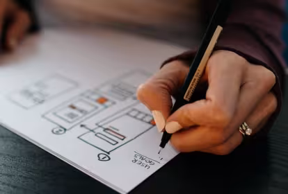 Emakume baten eskuak diseinu bat marrazten