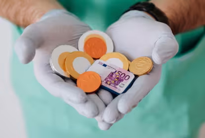 Un sanitario coge entre sus manos monedas de chocolate